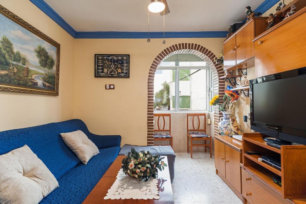 a living room with a blue couch and a tv at Apartamento Oliva in Barbate