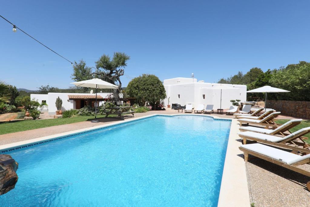 een zwembad met ligstoelen en een huis bij Can Caseres in Santa Eularia des Riu