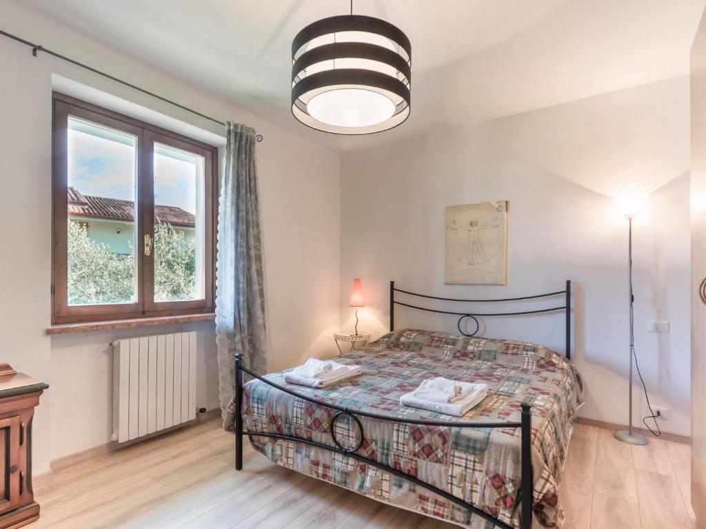 sypialnia z łóżkiem i dużym oknem w obiekcie Appartamento Bella Cora w mieście Lazise