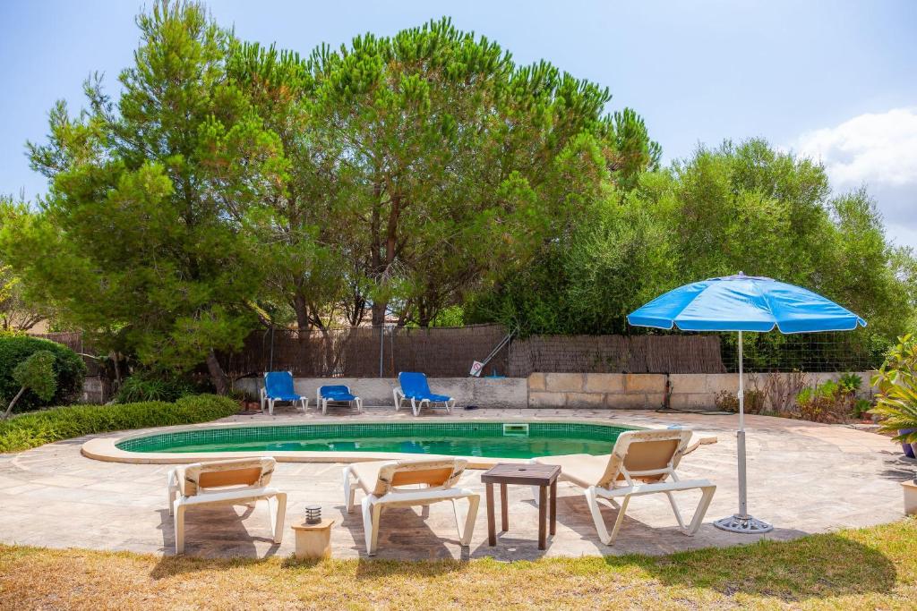 a pool with chairs and a table and an umbrella at Can Me Sents in Pollença