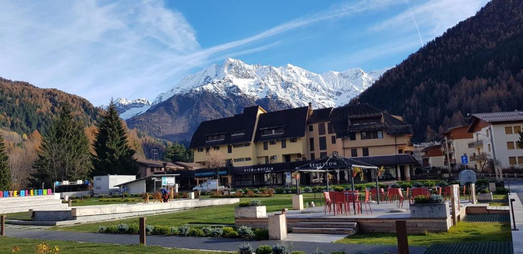 Un gran edificio con una montaña al fondo. en Luminoso appartamento centrale, en Ponte di Legno