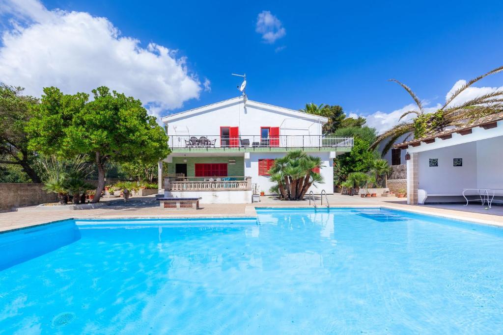 a large swimming pool in front of a house at Es Pins Gran in Font de Sa Cala