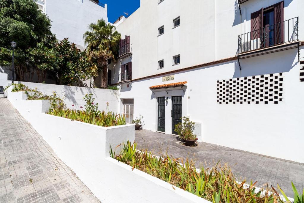 une maison blanche avec des murs et des plantes blancs dans l'établissement Apartamento Los Remedios Con Patio Andaluz, à Vejer de la Frontera
