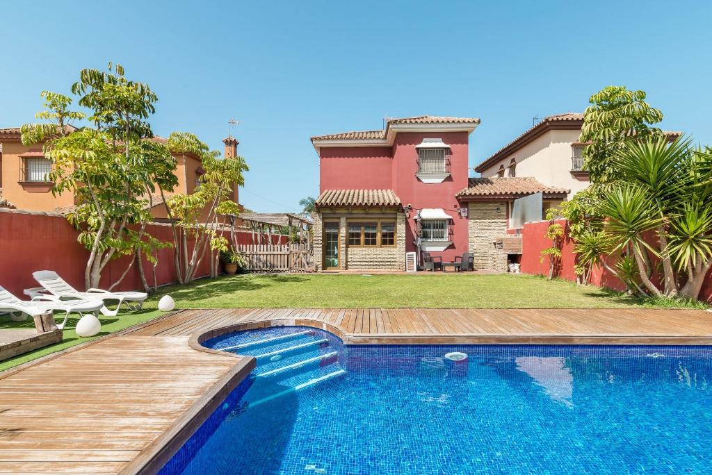 a house with a swimming pool in front of a house at Villa Marty - Mayores De 25 Años in Chiclana de la Frontera