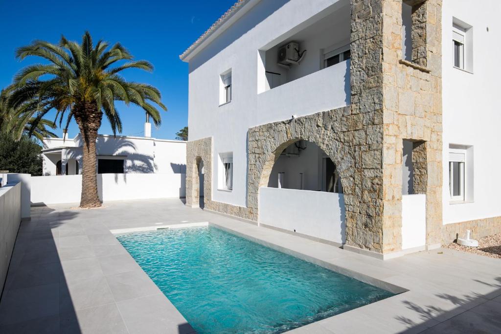 a villa with a swimming pool in front of a building at Apartamento Marei 1 in Cala Blanca