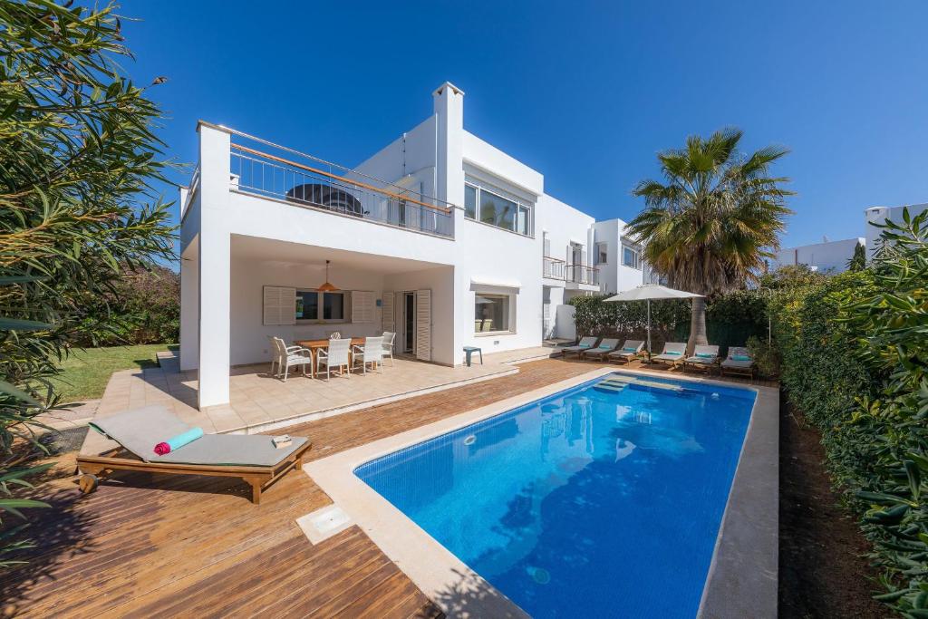 a villa with a swimming pool in front of a house at Villa Beatriz in Cala d´Or