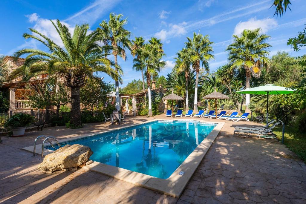 una piscina con palmeras y un complejo en Can Lopez Vara, en Campos