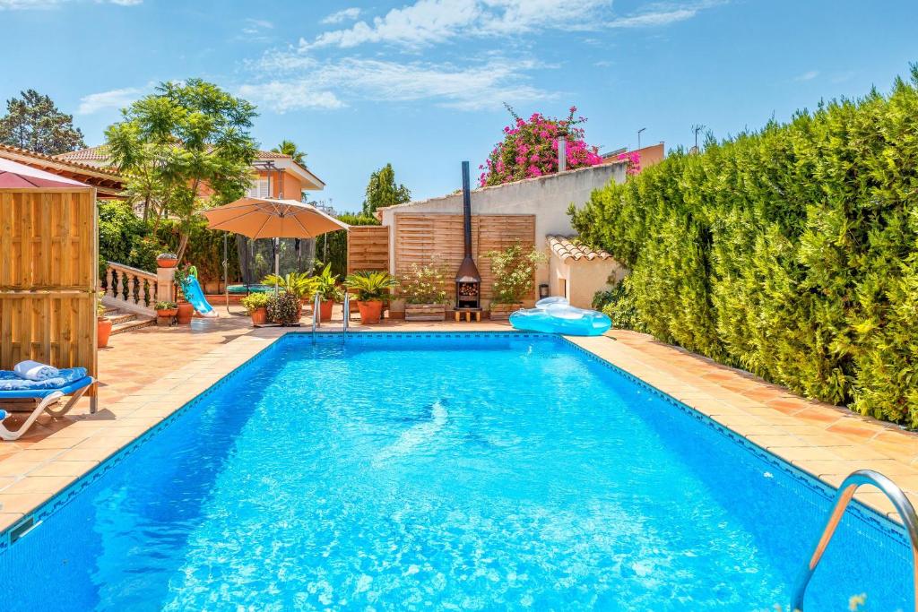 een zwembad in een tuin met een huis bij Dosmadres7 in Llucmajor