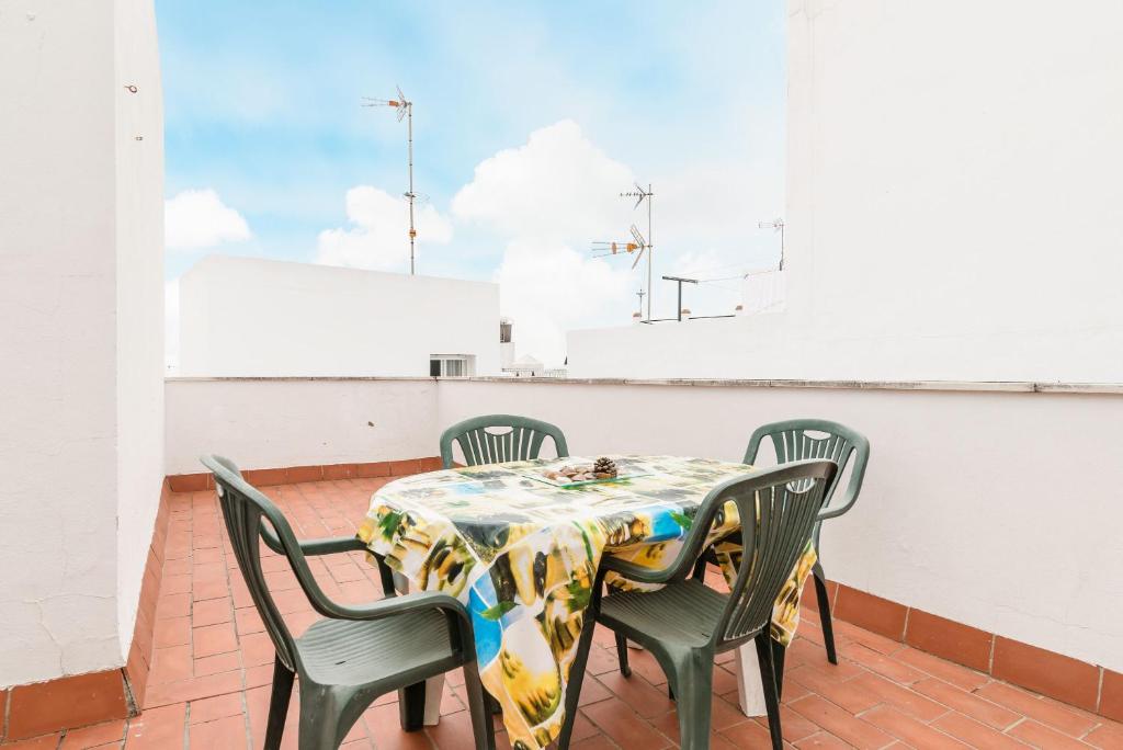una mesa y sillas en un balcón con vistas al cielo en Apartamento Miramar, en Conil de la Frontera