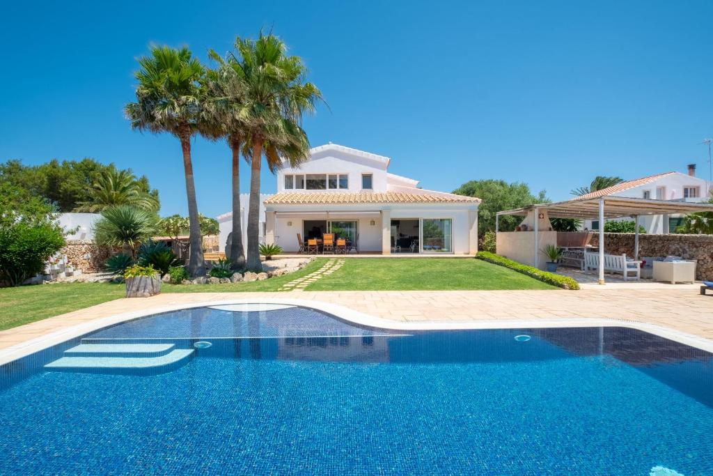 a villa with a swimming pool in front of a house at Abatzer in Ciutadella