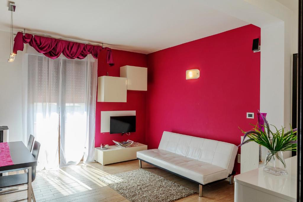 een woonkamer met rode muren en een witte bank bij Casa Vacanze Porto Torres in Porto Torres