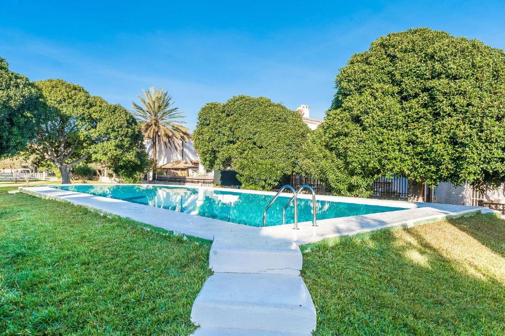 una piscina en medio de un patio con árboles en Modern apartment Rosmar iii Alcudia, en Alcudia