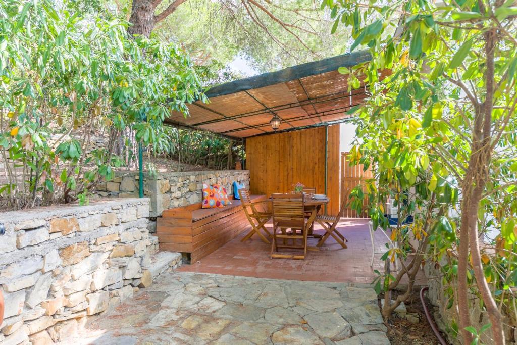 a wooden patio with a table and a stone wall at Appartamento La Marina trilocale in Marina di Campo