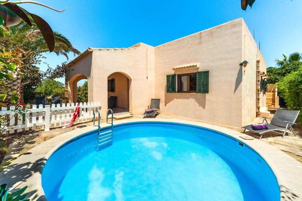a villa with a swimming pool in front of a house at Casa Mediterranea in Cala Santanyi