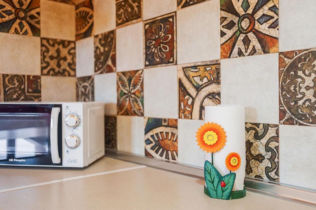 a kitchen counter with a microwave and a flower vase at Las tres hermanas in Conil de la Frontera