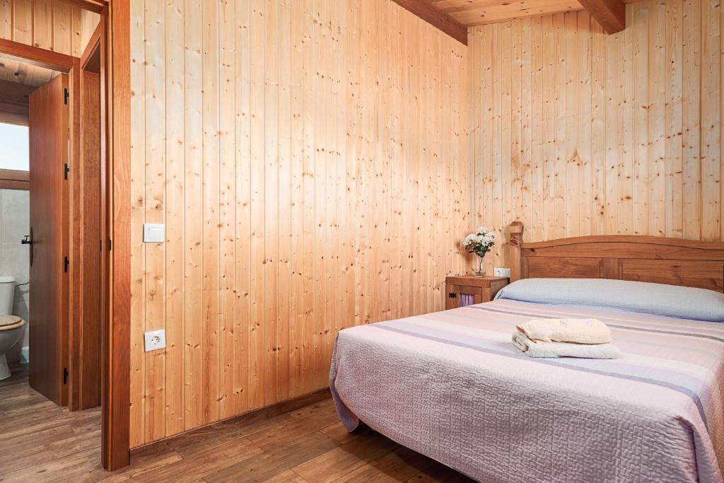 a bedroom with a bed in a wooden wall at Las tres hermanas in Conil de la Frontera