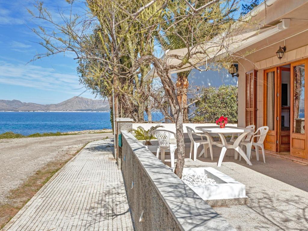 a house with a table and chairs next to the ocean at Villa Manresa in Alcudia