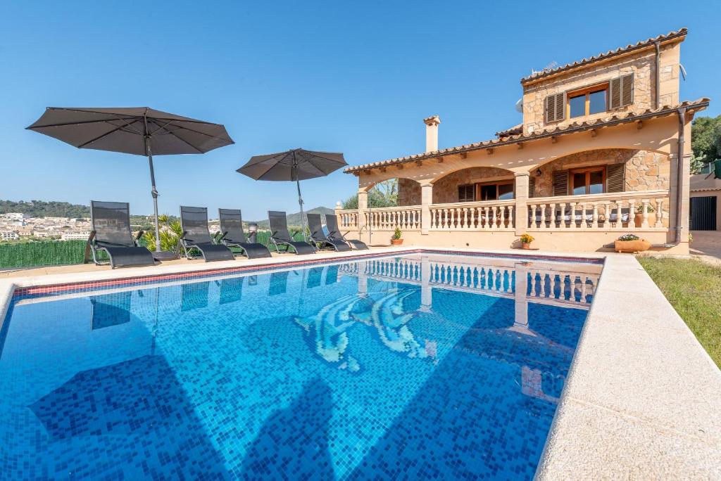 a villa with a swimming pool in front of a house at Solluna in Son Servera