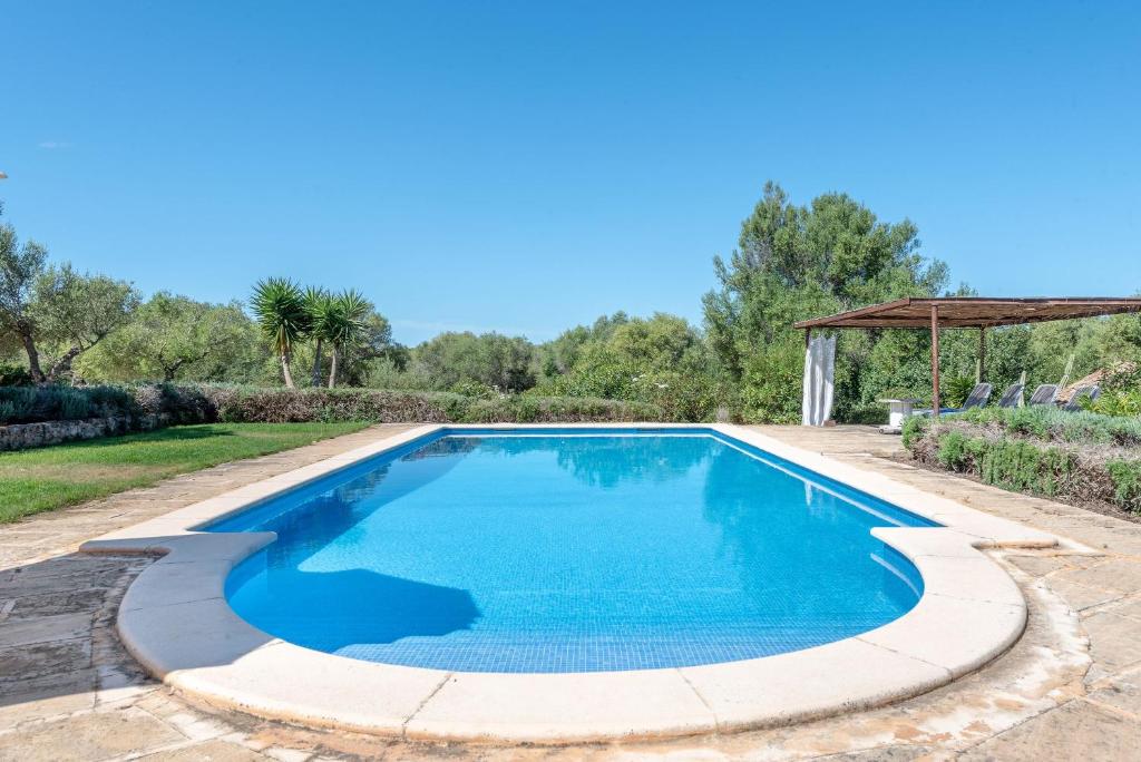 a swimming pool with blue water in a yard at Casa Yolanda in Sant Llorenç des Cardassar