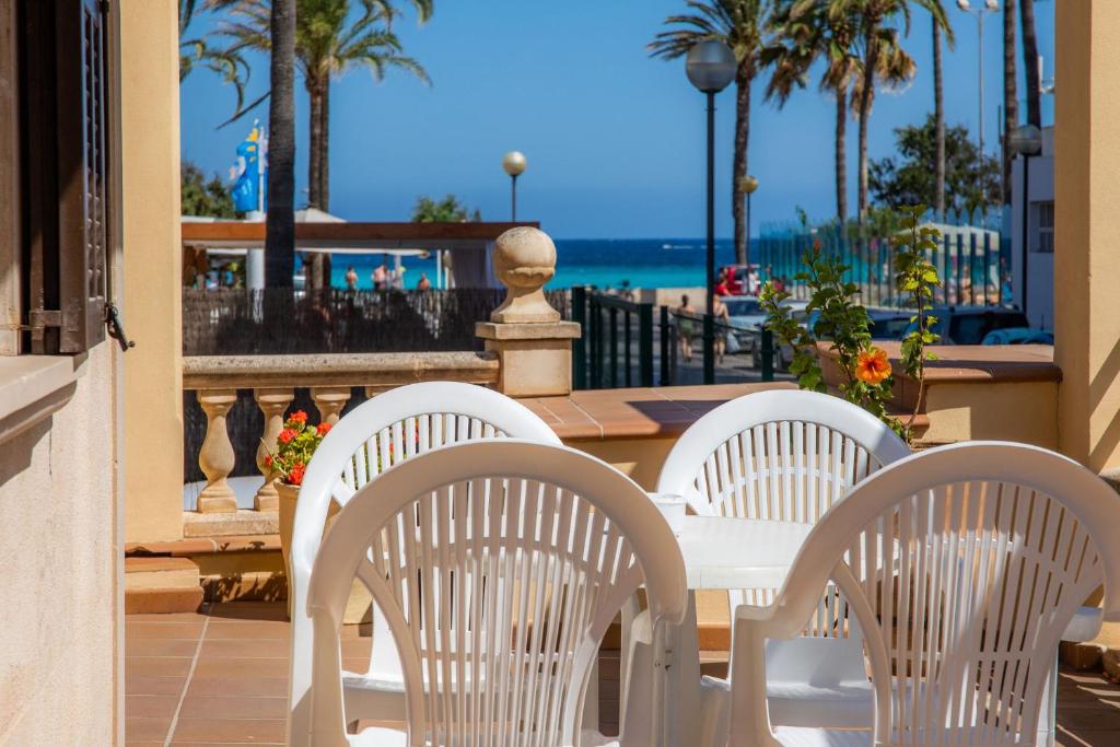 un tavolo bianco e sedie su un patio con vista sull'oceano di Dofí a Cala Millor