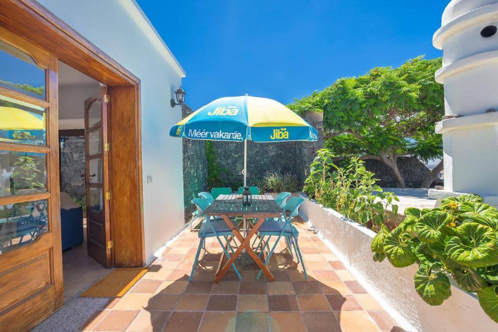 ティアスにあるVilla Jupeのパティオ(パラソルの下にテーブルと椅子付)