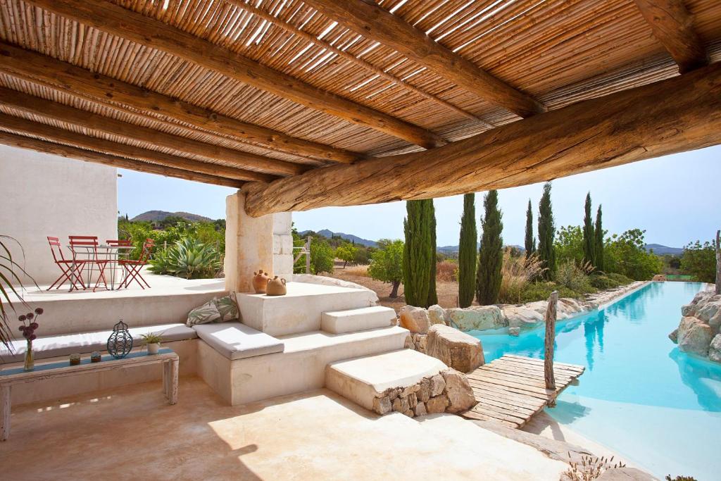 een woonkamer buiten met een zwembad en een huis bij Finca Calicant in Sant Llorenç des Cardassar