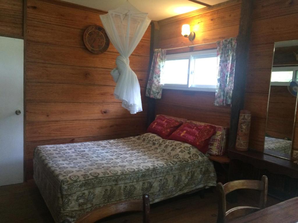 Habitación pequeña con cama y ventana en Cabaña Rio Lagarto, en Lívingston