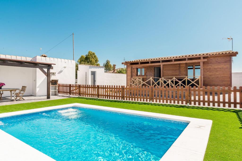 una piscina en un patio con una casa en Casa Hefestión en Conil de la Frontera