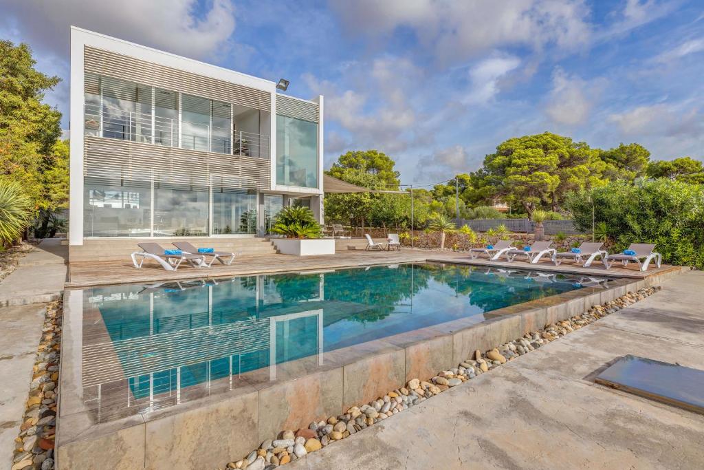 una piscina di fronte a una casa di Villa Es Pas a El Estanyol