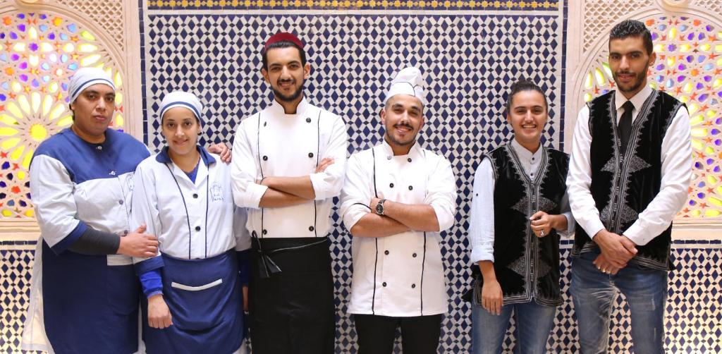 a group of chefs standing in front of a wall at Riad Farah in Fez