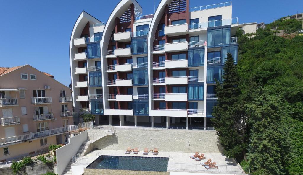 a building with a swimming pool in front of it at Apartments Aqua in Budva