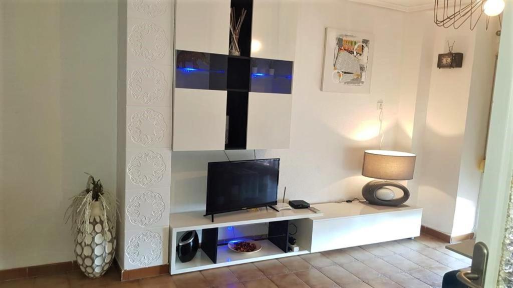 a living room with a tv on a white wall at Charming beachfront apartment/ Encantador apartamento frente al mar in Puerto de Sagunto