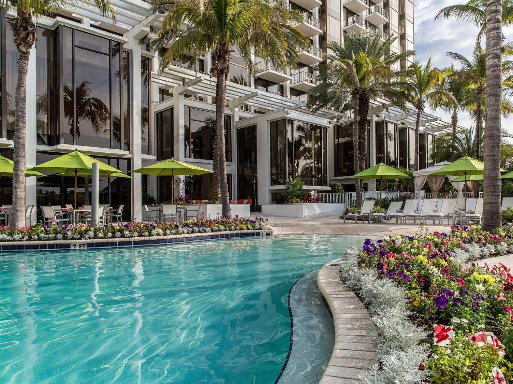 una piscina frente a un edificio con palmeras en Hyatt Regency Sarasota en Sarasota