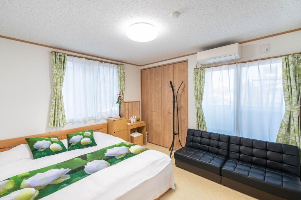 um quarto de hotel com uma cama e um sofá em Travel Palace Miyuki em Kawaguchi