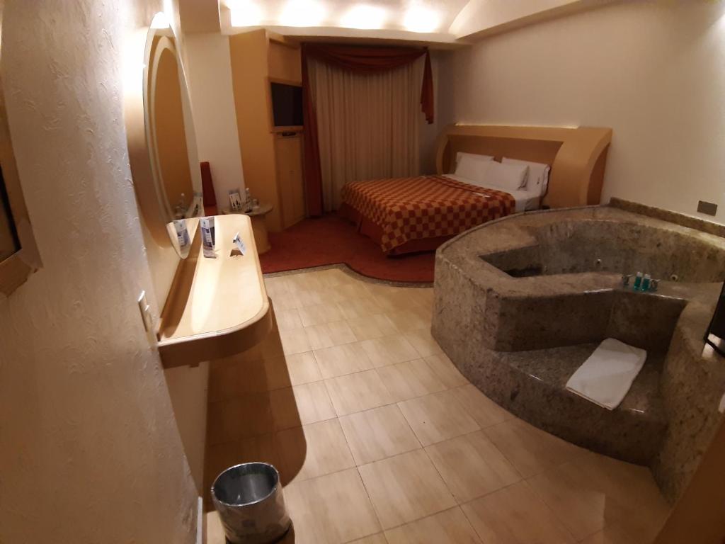A guest room includes a large built-in stone soaking tub beside the bed.