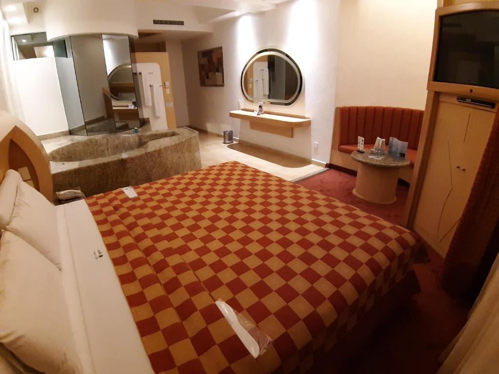 A one-bed room with a large mirrored vanity, stone basin and built-in television cabinet.