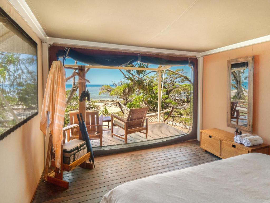 a bedroom with a view of the ocean from a balcony at Wilson Island in Wilson Island