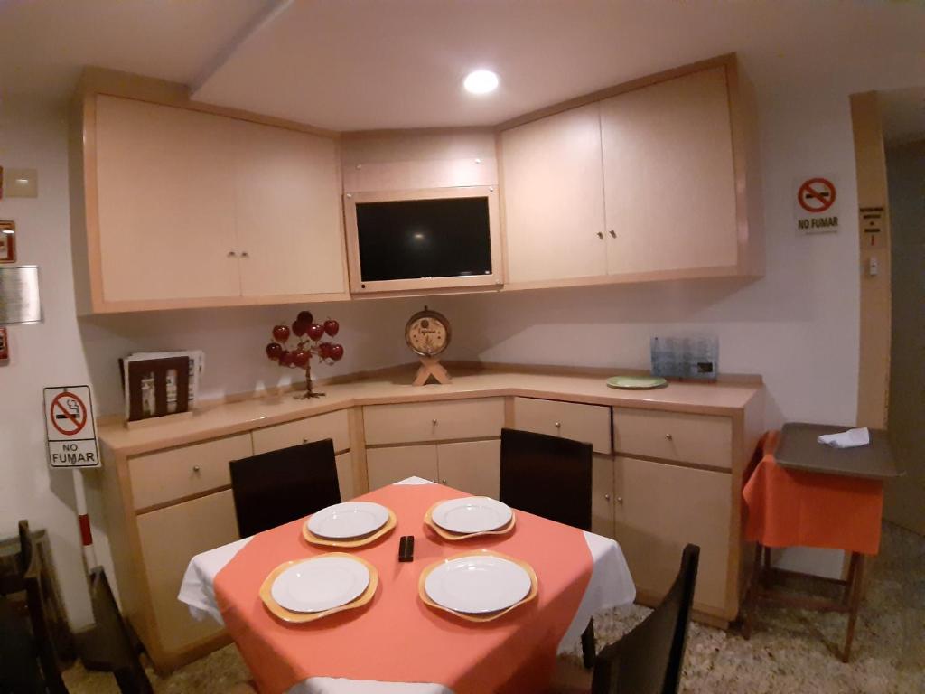 A compact dining room is arranged around a laid table and built-in service cabinetry.