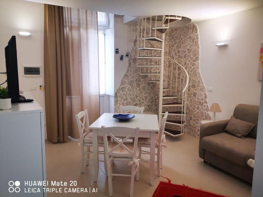 a living room with a table and a spiral staircase at CIVICO 63 in Brindisi