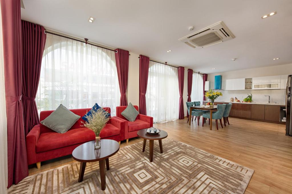 a living room with a red couch and a table at Sen Boutique Hotel in Da Nang