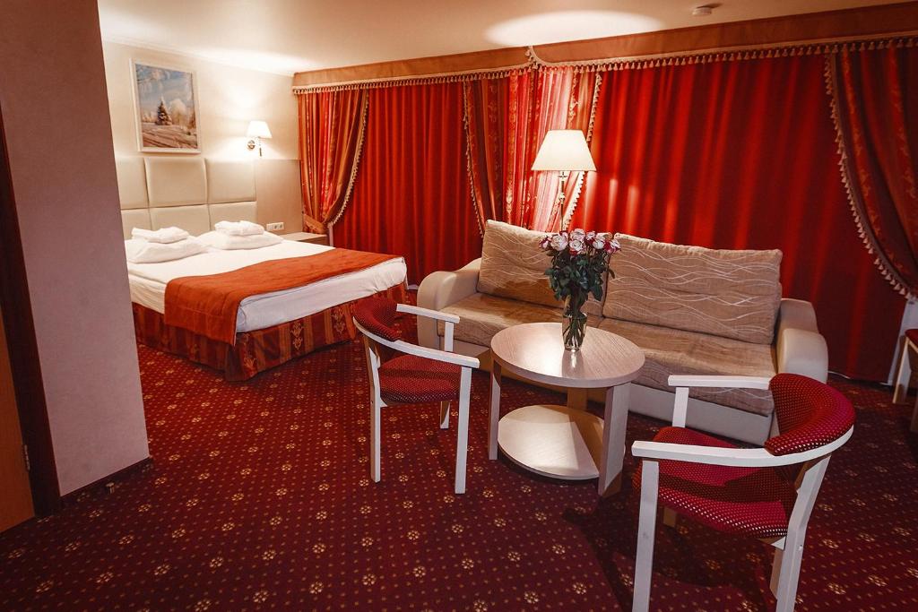 ノヴィ・ウレンゴイにあるAMAKS Polar Starのベッド、テーブル、椅子が備わるホテルルームです。
