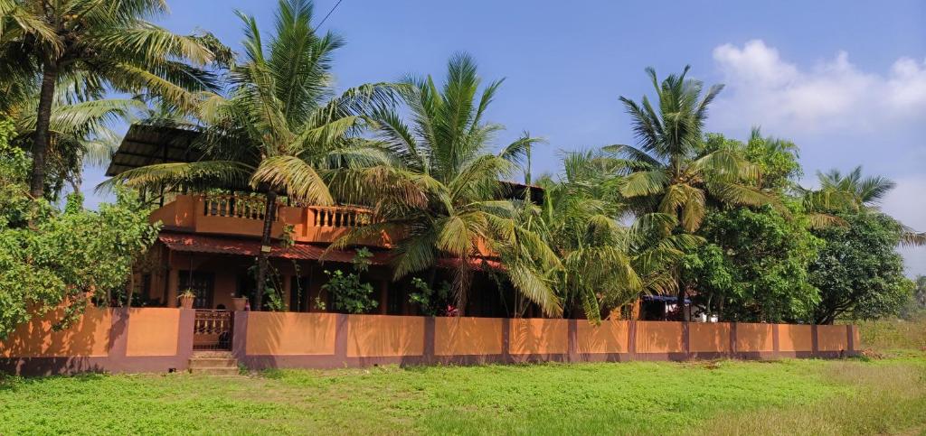 a house with palm trees in front of it at Anjuna Hideout in Anjuna