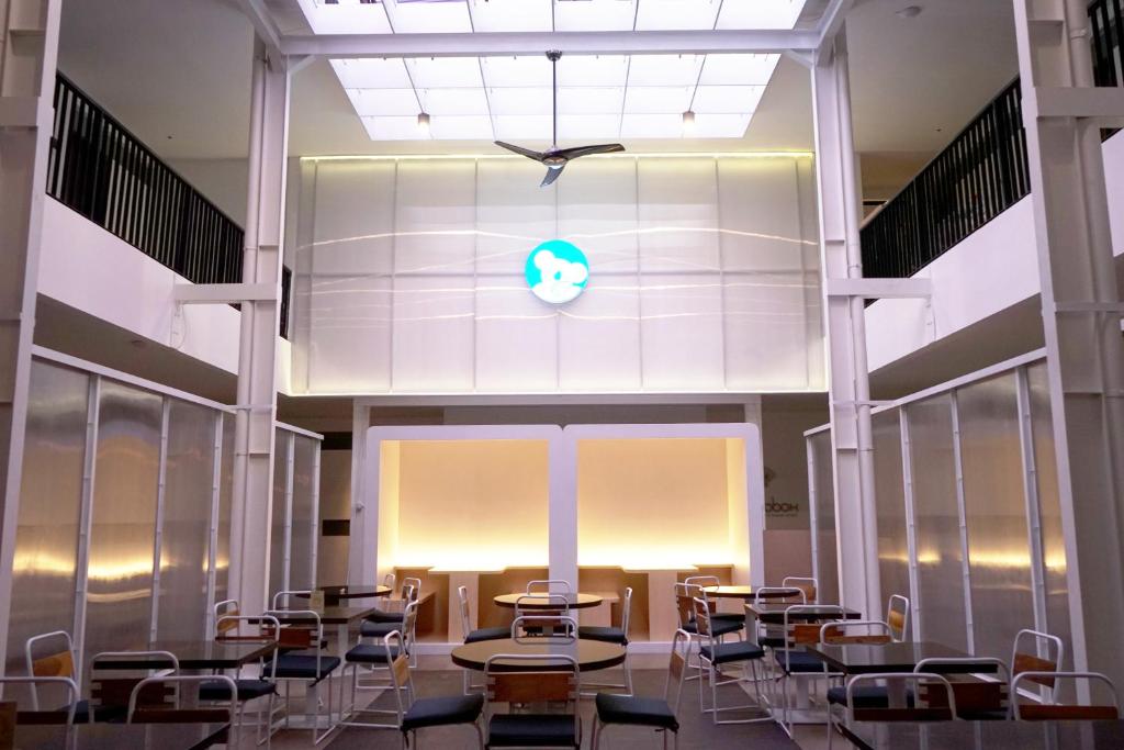 an empty room with tables and chairs in a building at Bobopod Cipaganti, Bandung in Bandung