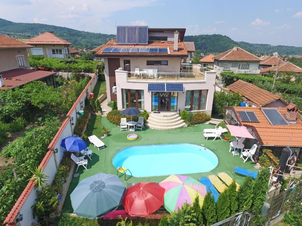 an aerial view of a house with a swimming pool and umbrellas at Guest House Camellia in Berkovitsa