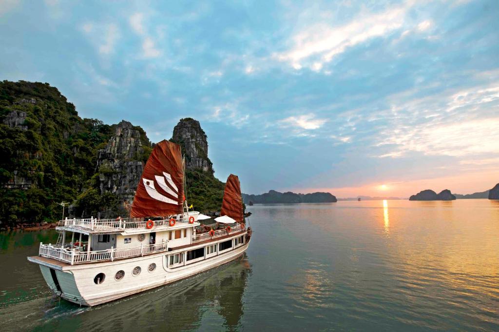 a boat with two large sails in the water at Bhaya Legend Cruises in Ha Long