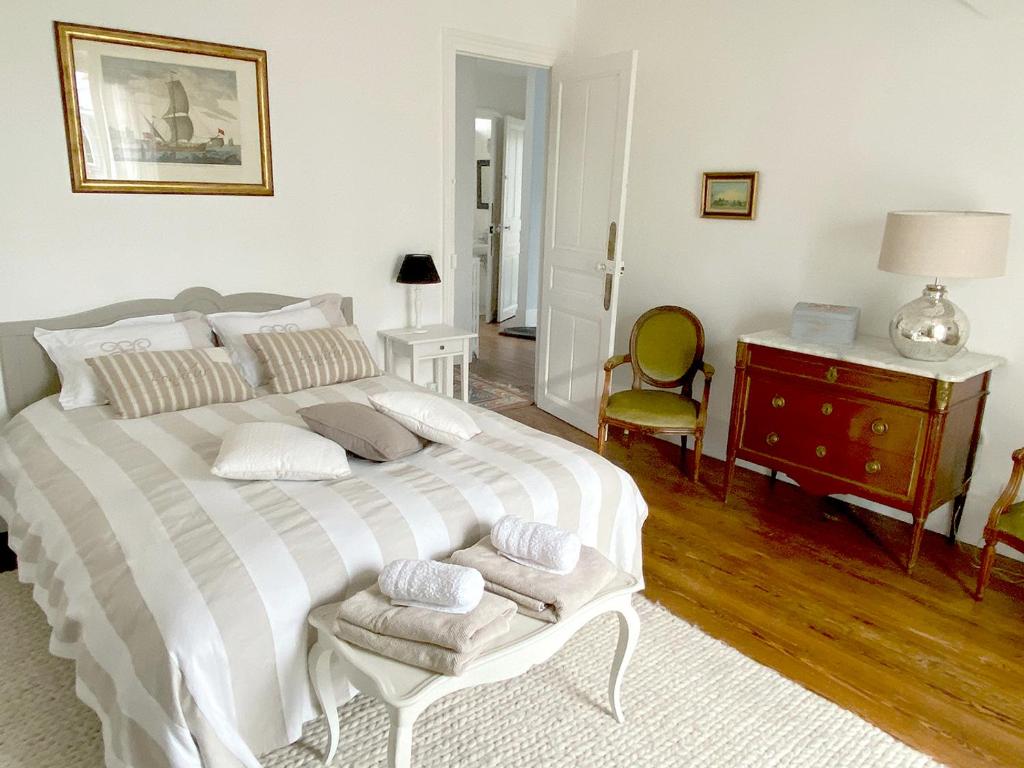 a bedroom with a large white bed and a desk at Les Chambres de LOUIS in Le Chesnay