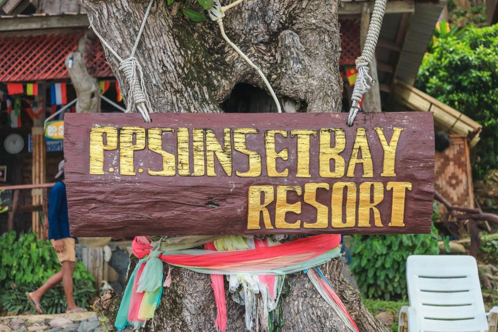 un panneau indiquant la station d'anniversaire suspendue sur un arbre dans l'établissement Phi Phi Sunset Bay Resort, sur les Îles Phi Phi