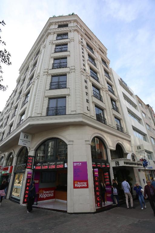 Un grand bâtiment blanc avec des personnes debout à l'extérieur dans l'établissement FOUR SEVEN HOTEL, à Istanbul