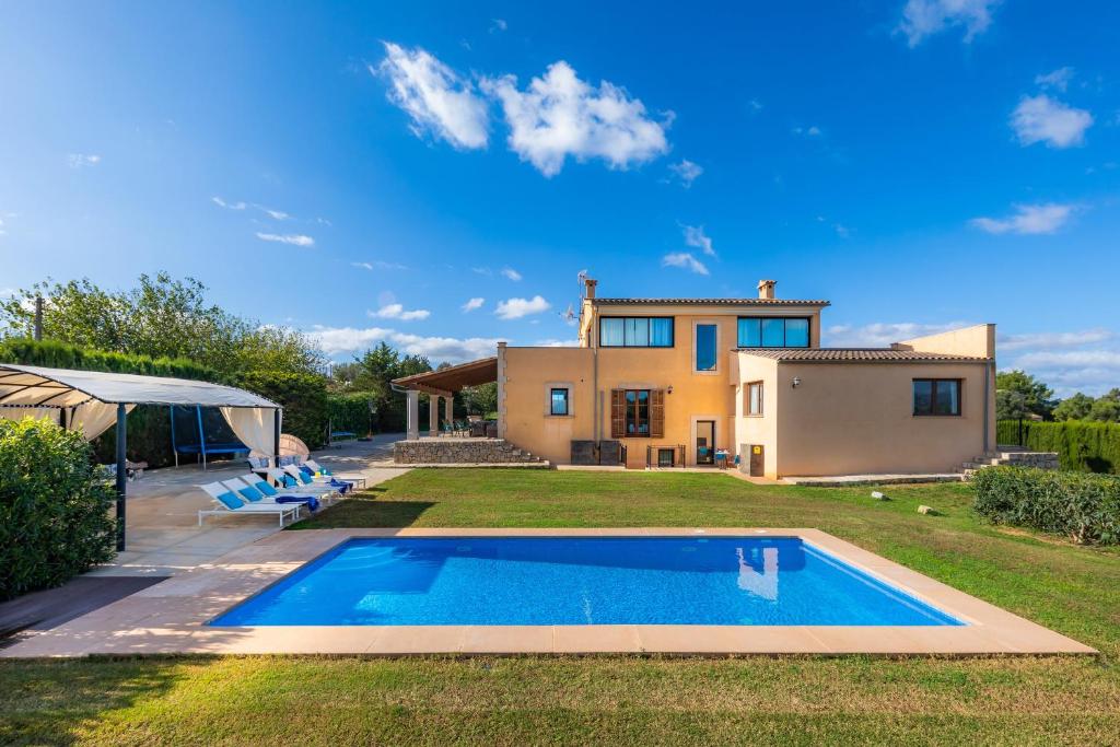 a villa with a swimming pool in front of a house at Finca Llum in Manacor