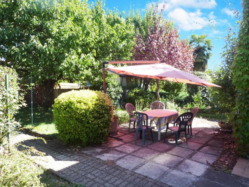 圖盧茲的住宿－Les Gardénias，花园内桌椅和遮阳伞